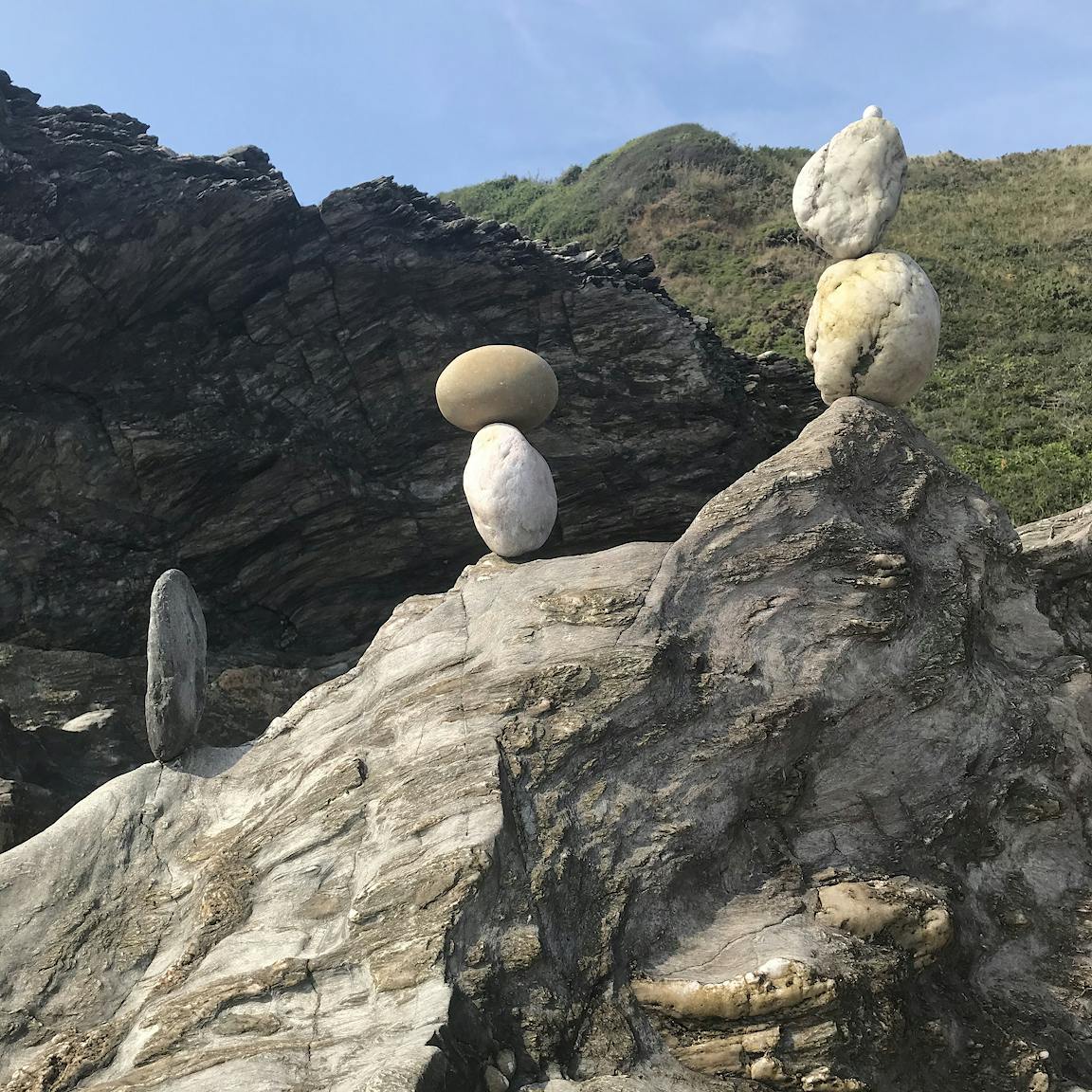 Stones are balanced on top of a large boulder.